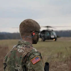 Student in military uniform with helicopter in background